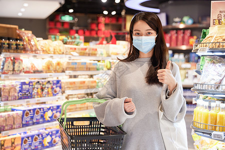 佩戴口罩逛超市的青年女性点赞手势图片