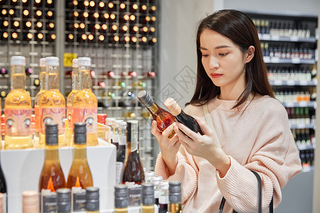 青年女性线下门店挑选酒水高清图片