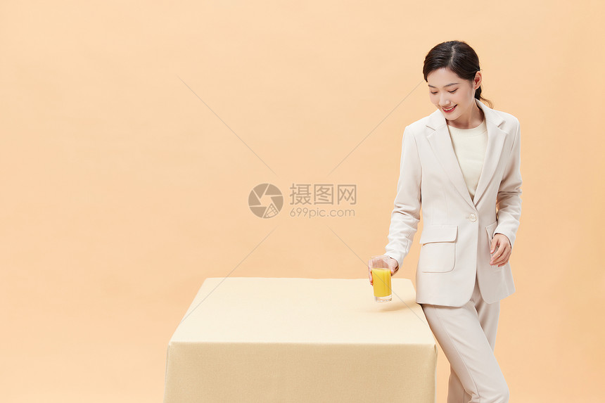 商务女性手拿一杯橙汁图片