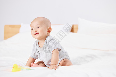 幼儿推拿可爱的婴儿居家坐在床上背景