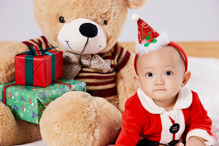 圣诞宝宝与圣诞毛绒玩具熊背景图片