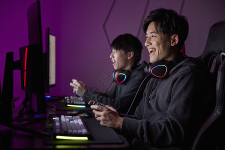青少年玩电脑青年男性熬夜通宵使用手柄玩电脑游戏背景