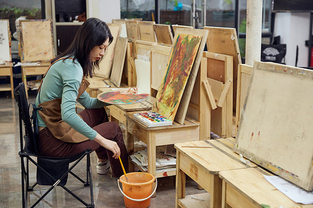 油画桶在画室画色彩画的女性背景