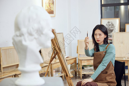 手绘椅子在画室画石膏像的女学生背景