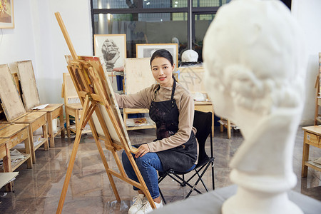 手绘椅子在画室画石膏像的女学生背景