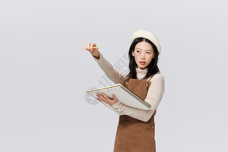 笔记本电脑手绘抱着绘画板的女性画家形象背景