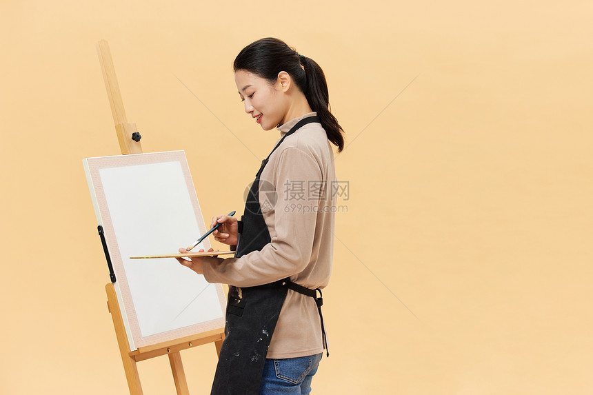 正在画画的年轻女性图片