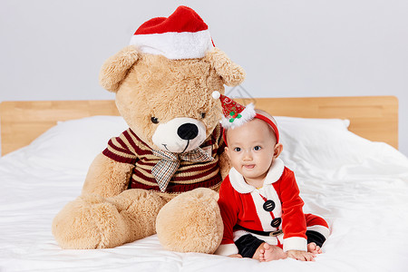 装扮熊男孩圣诞宝宝与圣诞毛绒玩具熊背景
