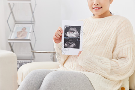 人物图像孕期妈妈居家坐沙发上看B超图像背景