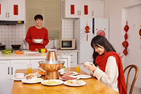 年轻情侣居家吃火锅过新年背景图片