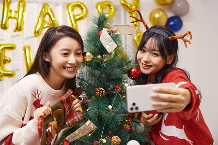 青年美女与圣诞树自拍背景图片