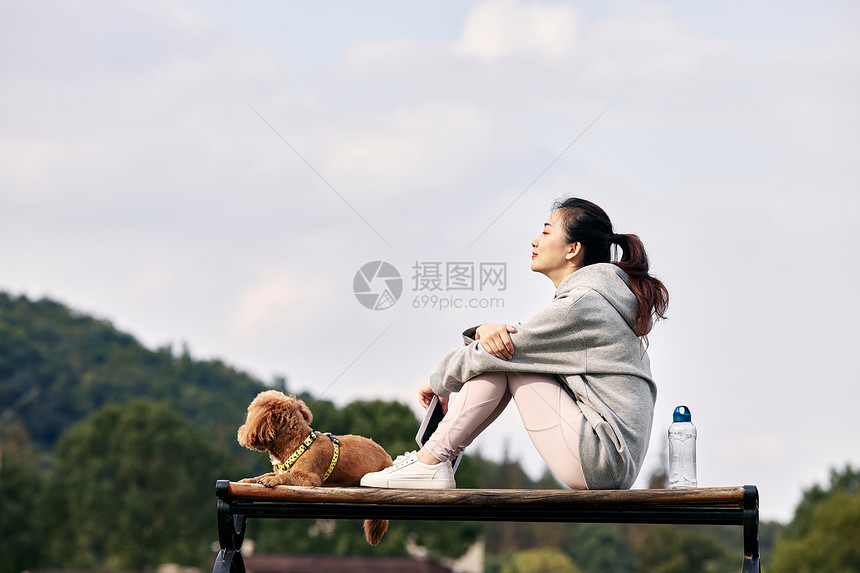 坐在长椅上的运动少女和萌宠泰迪图片