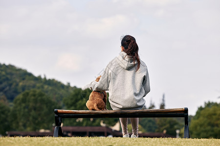 中国冠毛犬运动少女和萌宠泰迪的背影背景