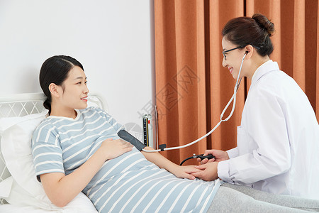 医孕妇妇产科医生为孕妇测量血压背景