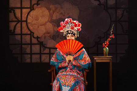 国粹戏曲京剧美女手拿红纸扇遮面背景
