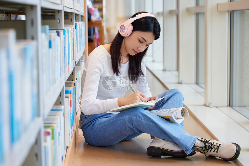 女学生在图书馆看书听音乐图片