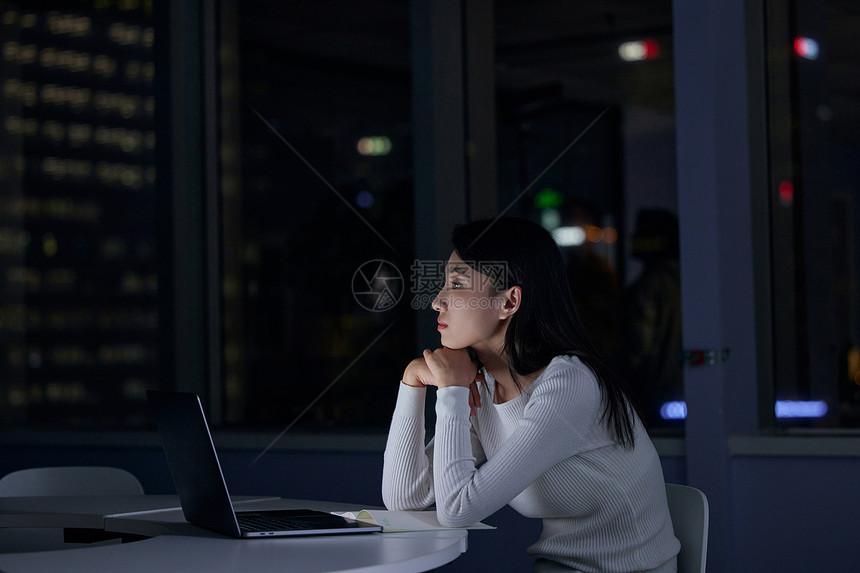 青年女性在公司熬夜加班图片