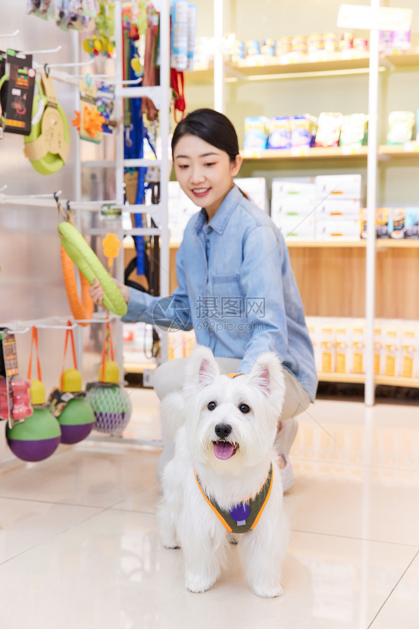 美女主人带宠物狗狗逛宠物店选购商品图片