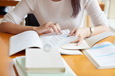 考研书籍青年女性在自习室学习特写背景