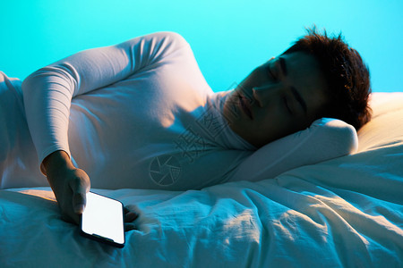 年轻男性玩手机睡着图片