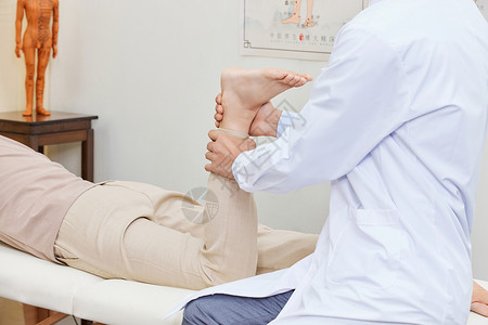 穴位按压男中医为患者按摩脚踝关节背景