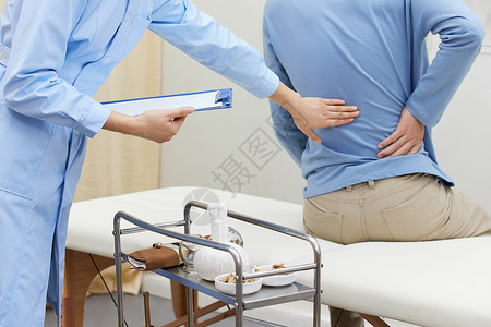 中医病房中医护士为患者检查腰部患处背景