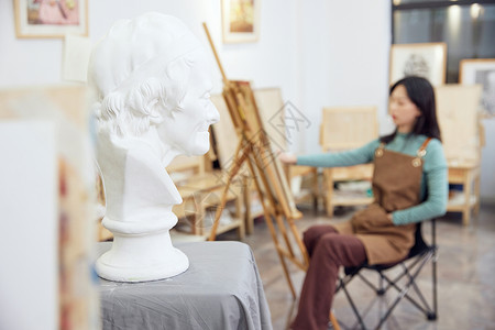 石膏像雅典娜女性坐在画室画石膏像背景