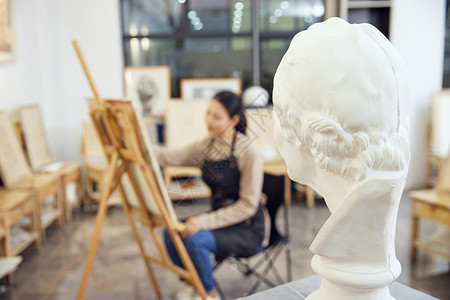 素描人头像女性坐在画室画石膏像背景