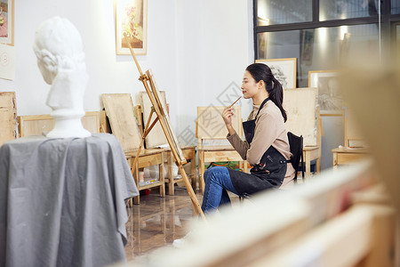 女性坐在画室画石膏像高清图片