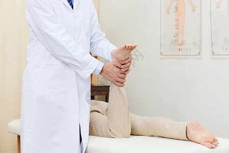 寻医问诊男中医为患者按摩脚部穴位特写背景