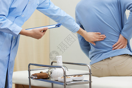 中医护士检查患者腰部患处高清图片