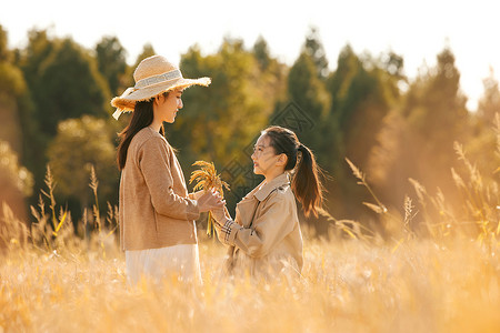 母女二人秋天在稻田里郊游图片