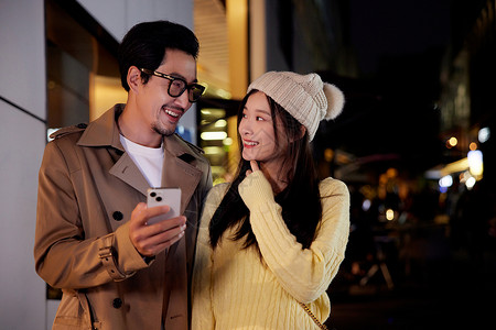 夜晚冬季情侣约会逛街对视微笑图片