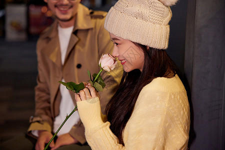 甜蜜依偎情侣青年女性收到玫瑰花表示开心背景