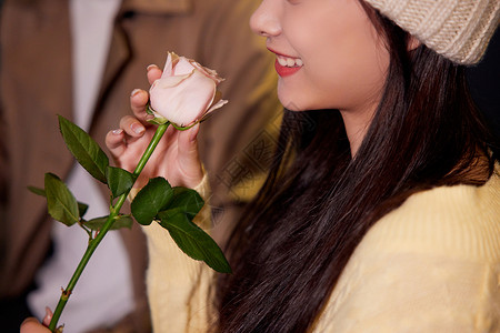 冬日夜晚女性收到玫瑰花开心特写图片