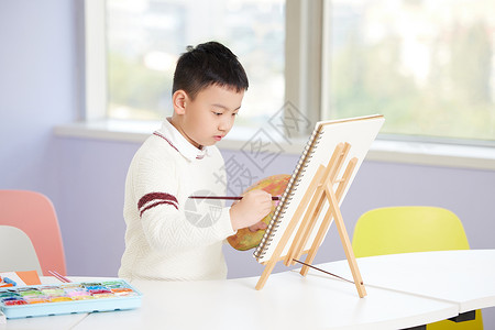 课外学习美术绘画课的小男孩图片