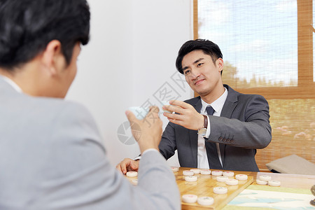 商务人士茶室休闲下棋背景图片