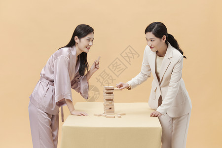 叠叠乐商务女性和居家女性玩桌游背景