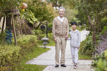 爷爷带着孙子外出散步高清图片