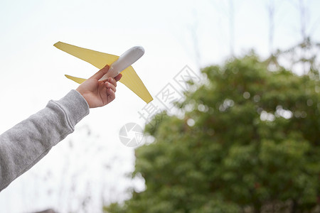 黄色纸飞机儿童举起飞机翱翔特写背景