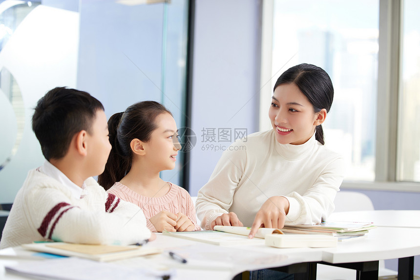 年轻女老师辅导小朋友学习图片