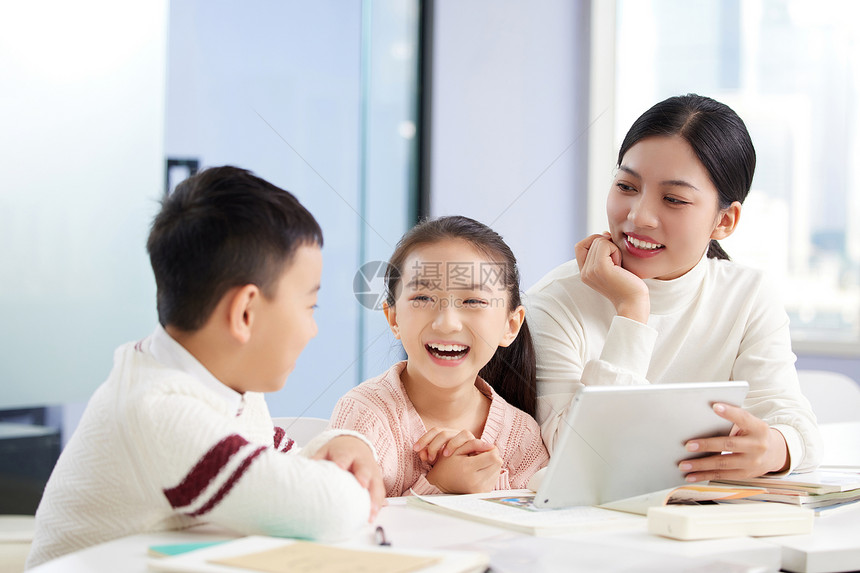 年轻女老师辅导小朋友学习图片