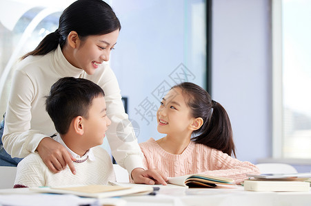 做作业的女孩年轻女老师辅导小朋友学习背景