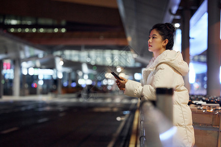 冬季旅行人物美女夜间出行等待公交车背景