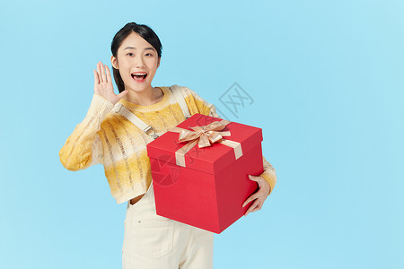 年轻美女抱着礼物盒背景图片