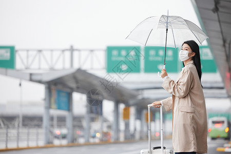 戴口罩户外等车的女性背景图片