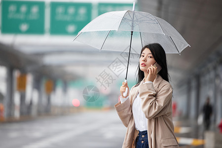 雨伞在机场外撑伞等车的女性背景