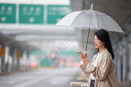 外门市在机场外撑伞等车的女性背景