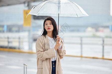 下雨天撑伞等候的女性高清图片