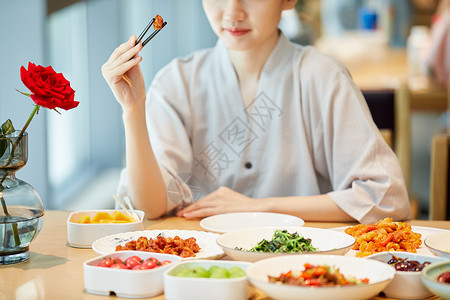 青年区青年美女在汤泉馆美食区夹菜特写背景